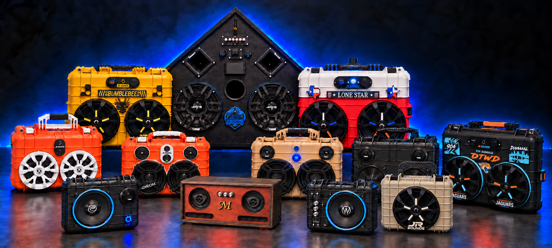 JR Sounds speaker collection, including Bumblebee, Lone Star, orange and black Apache case builds, a triangular cabinet, a wooden stereo, a Jaguars build and a tan single-speaker case